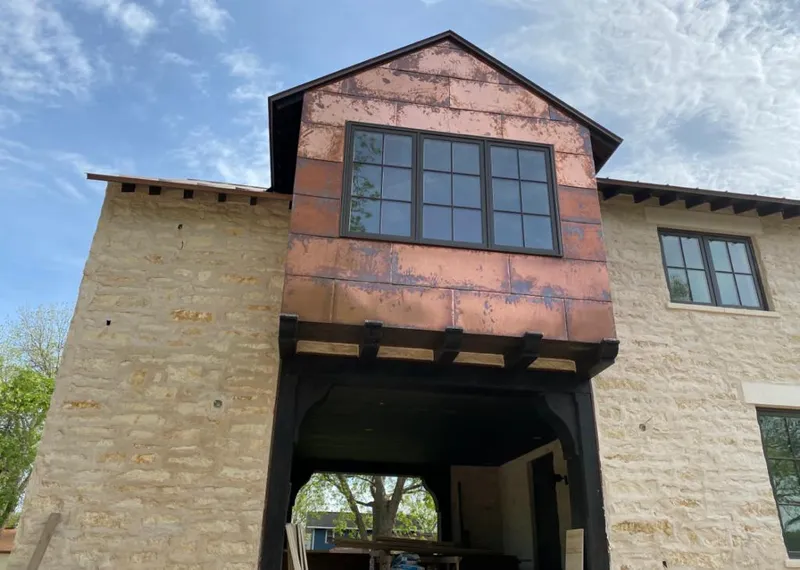 Copper metal panel facade on a stone building for Skylight Installation in Skidaway Island